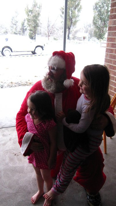 Santa hugs two girls