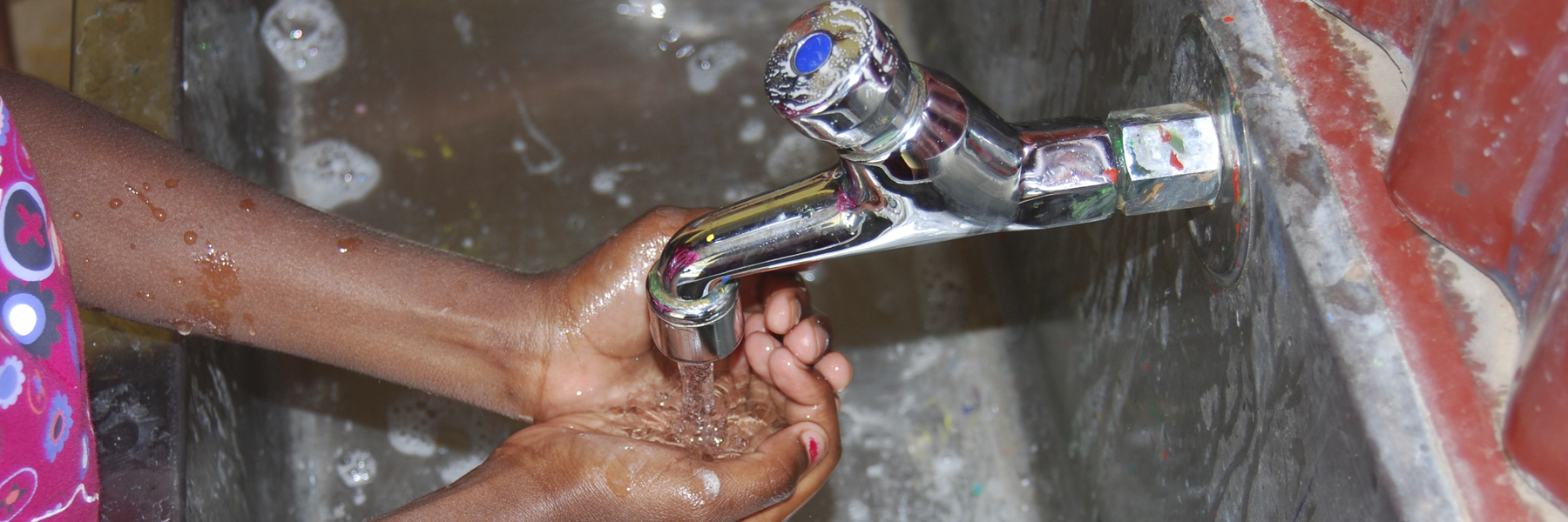 Hands being washed under tap