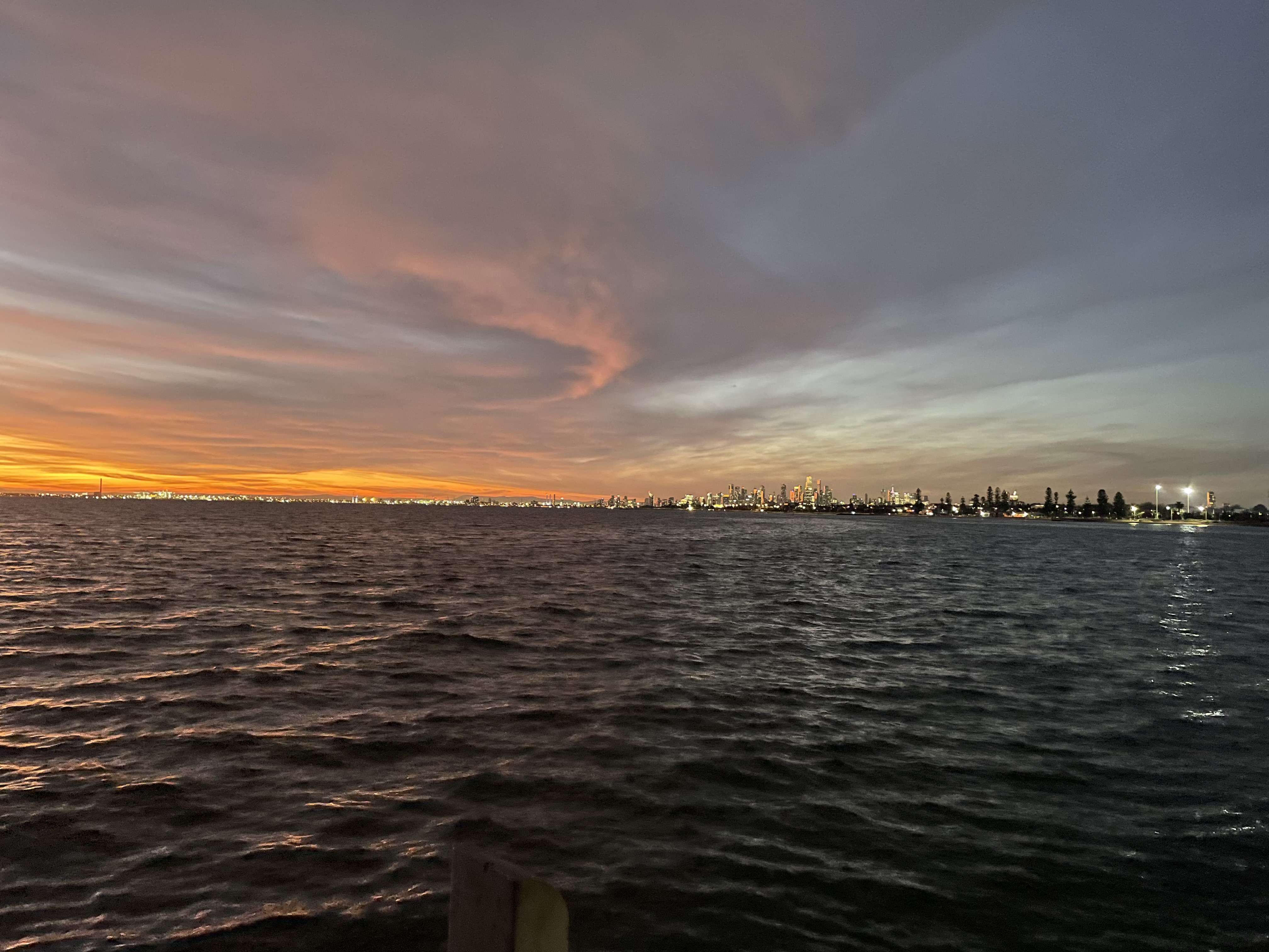 A photo of the sunset and ocean, with Melbourne city in the disctance