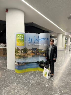 Ash standing in front of conference banner