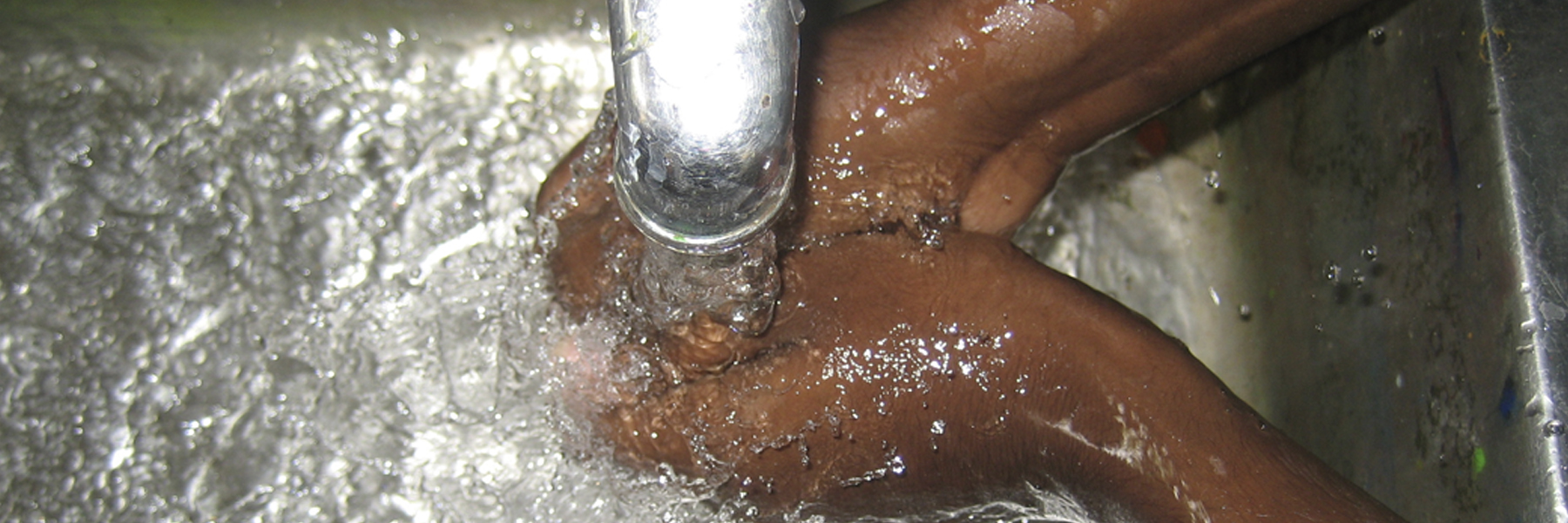 Hands being washed under tap