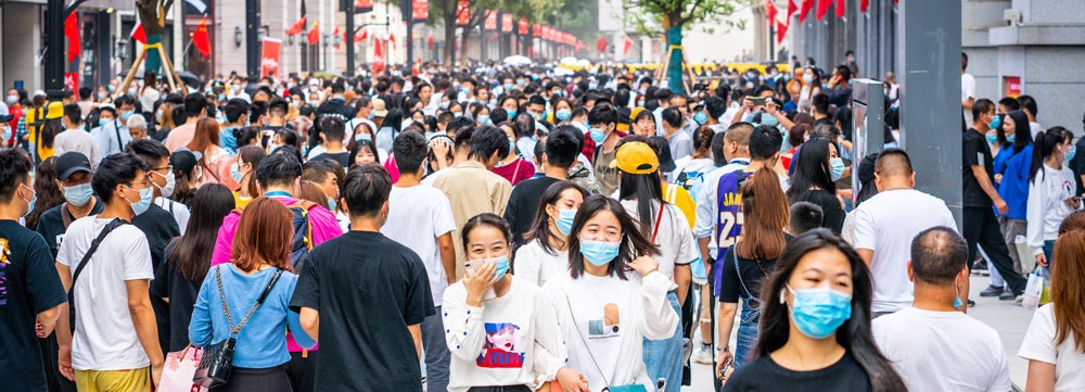 Crowd of people wearing surgical face mask on a pedestrian road in Wuhan Hubei China