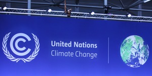 COP26 panel sitting behind desks on stage. COP26 Logo in background
