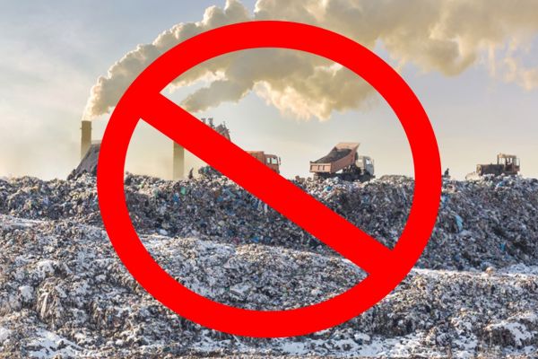 Ban Symbol over image of Dump trucks unloading garbage over vast landfill. Smoking industrial stacks on background. Environmental pollution.
